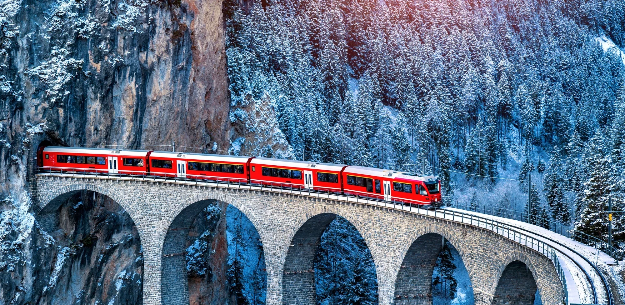 Roter Zug fährt durch die schöne Berglandschaft der Schweizer Alpen