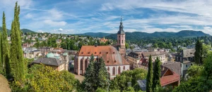 Stiftskirche in Baden-Baden mit weiteren Häusern und Wäldern und Bergen im Hintergrund