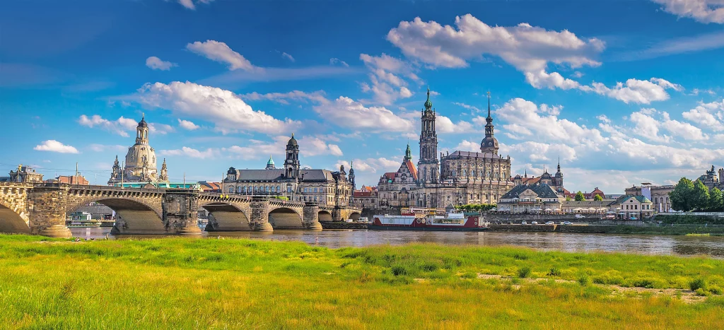 Bahn und Hotel Dresden mit Elbpanorama auf Augustusbrücke bei strahlend blauem Himmel