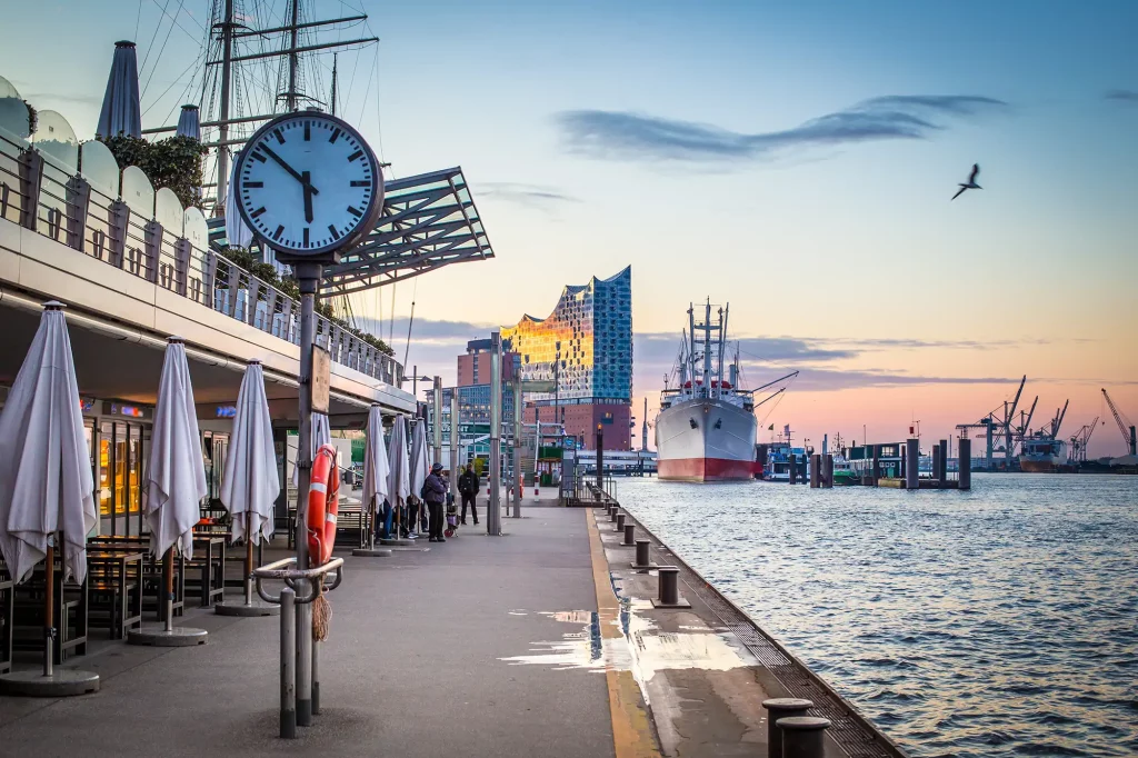 Hamburger Hafen mit Blick auf Elbphilharmonie im Sonnenuntergang bei einer Reise Bahn und Hotel Hamburg